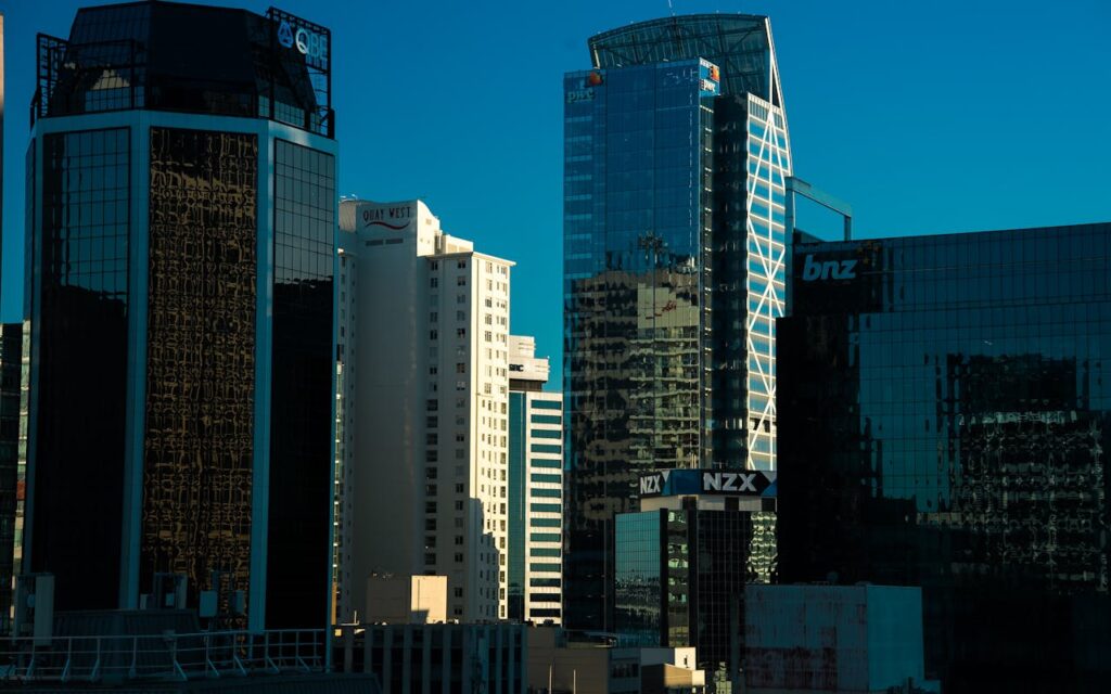 Modern skyscrapers in Auckland, New Zealand under bright daylight, reflecting urban architecture.